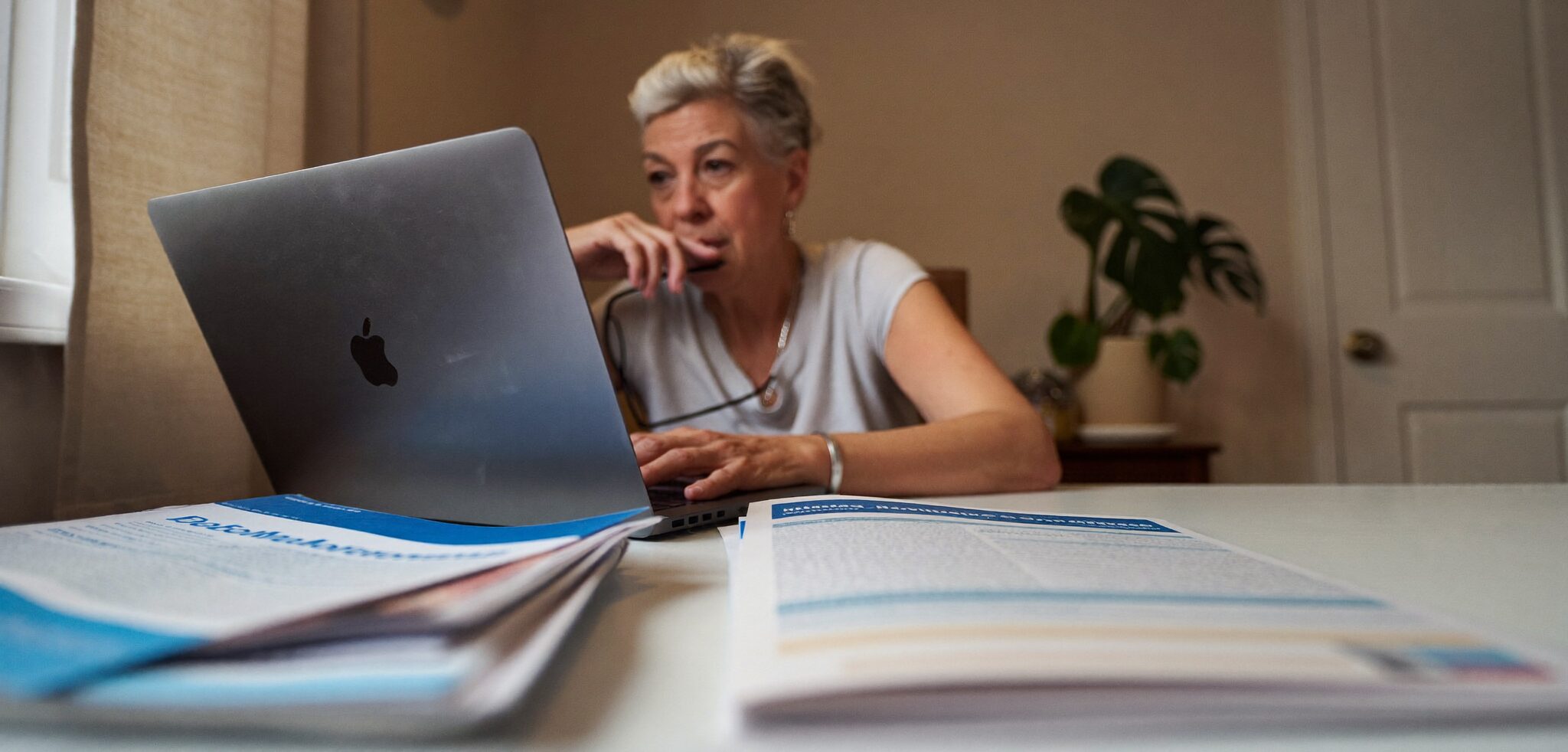 Older woman researching Medicare plan options on her laptop during open enrollment