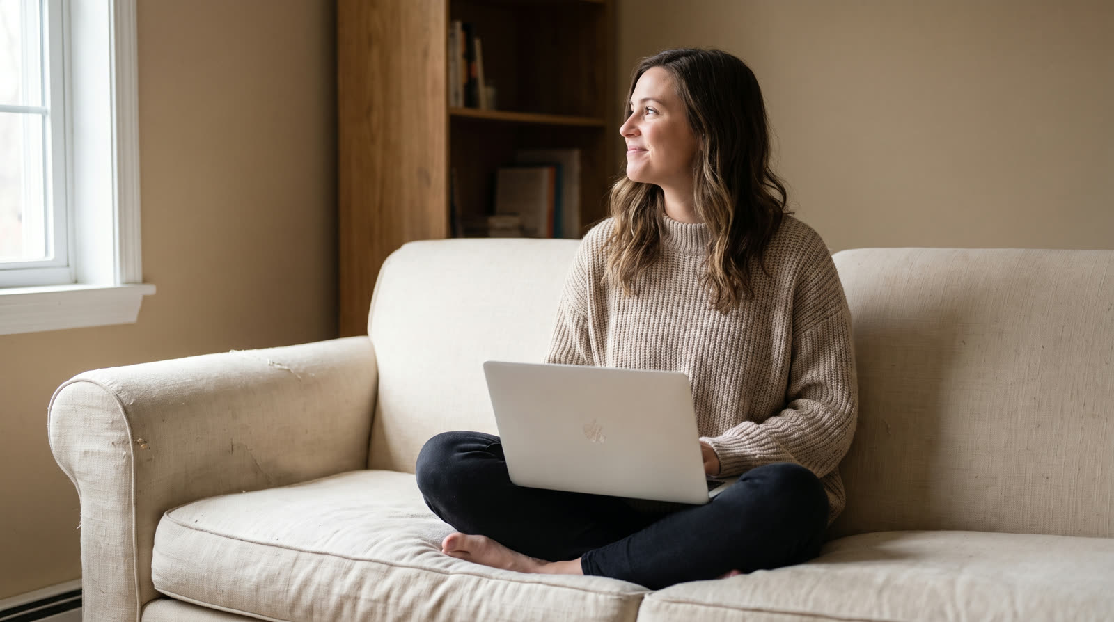 Young woman checking something on her laptop from the couch