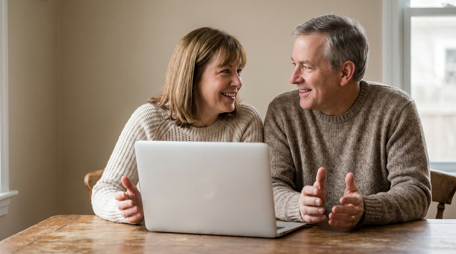 Couple in their fifties reviewing options together on a laptop